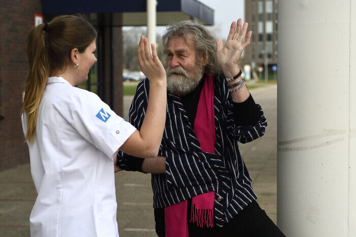 Plezier in jouw zorgbaan: Verzorgster van Medical die cliënt een high five geeft